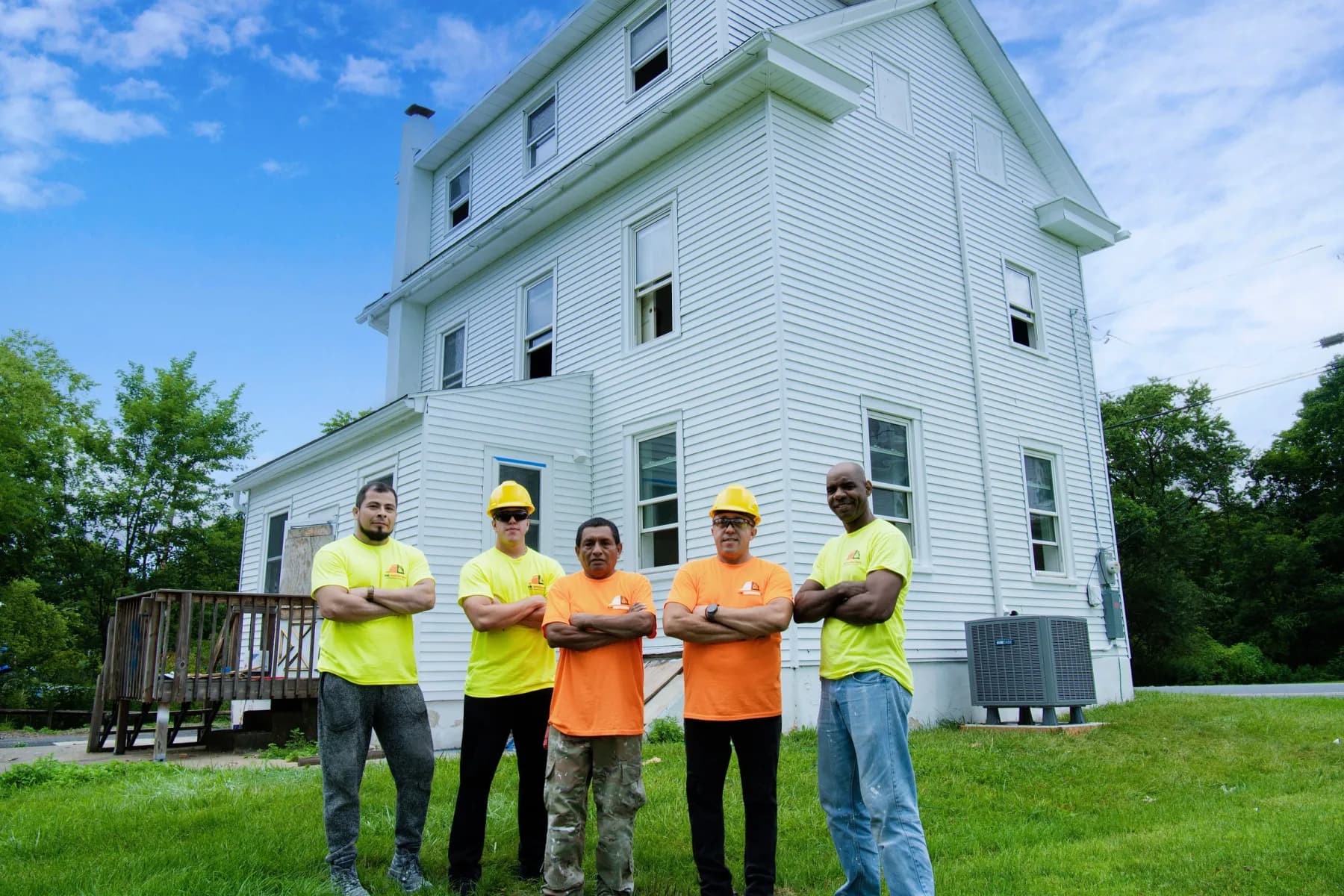 The Vene Construction crew in front of a three-story home they are renovating