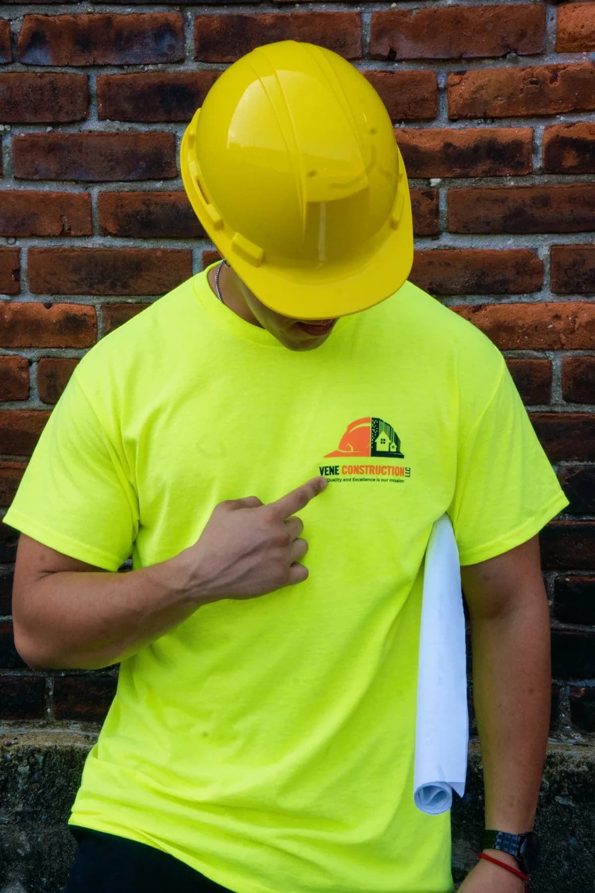 A Vene Construction owner pointing to the company logo on his shirt
