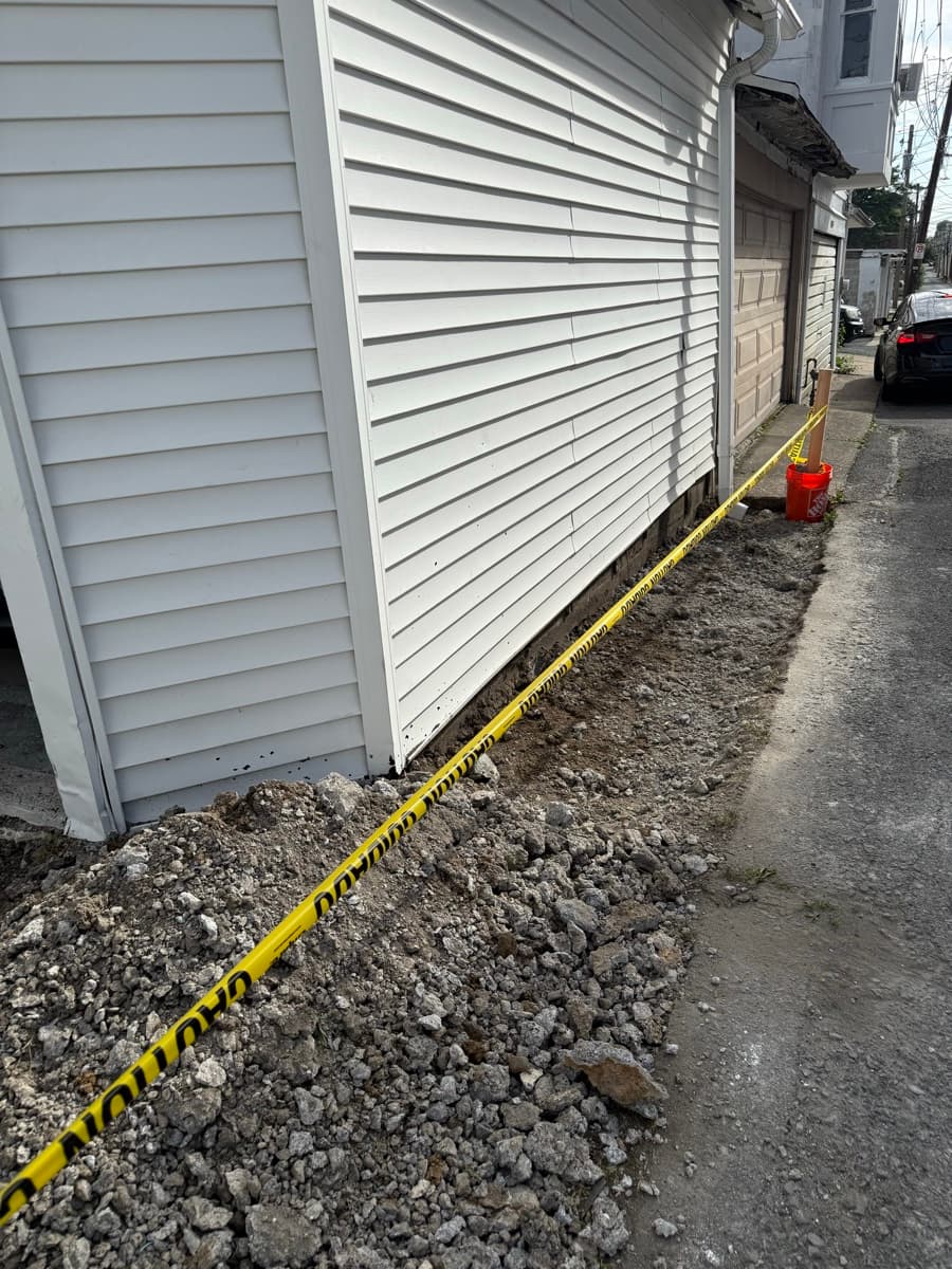 Fresh siding and grade work along the side of a house