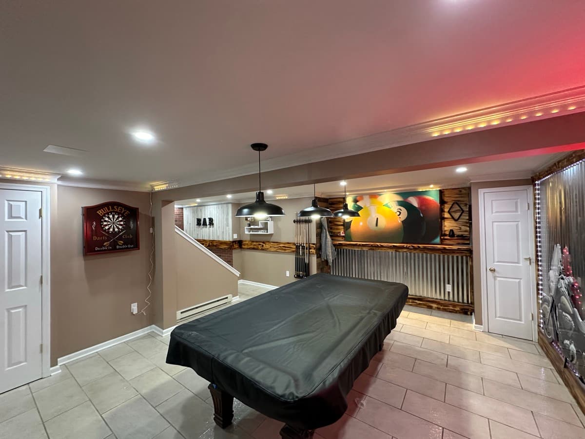 Finished basement entertainment space with bar and seating area