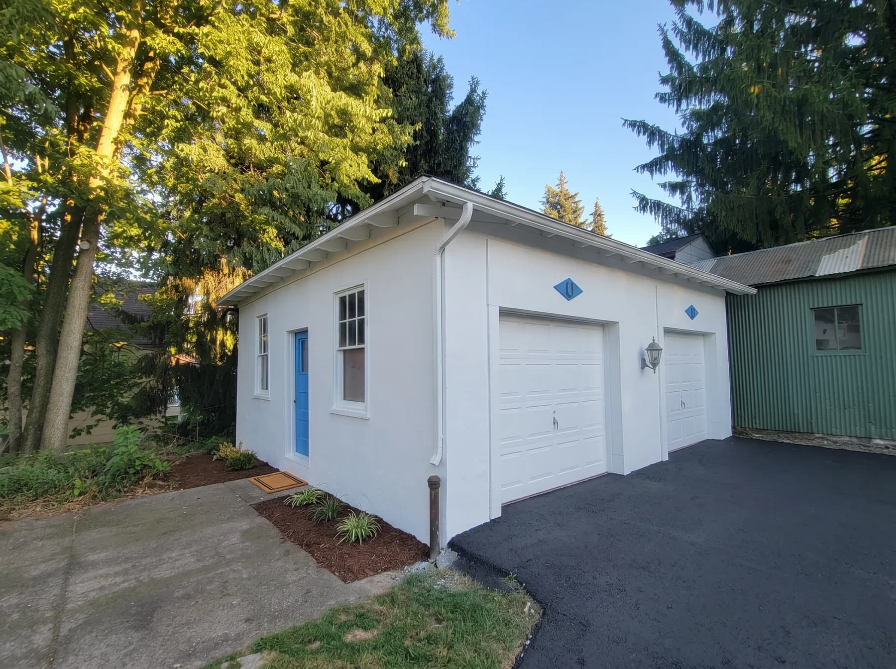 Side view of detached garage after exterior painting with blue side door in Bethlehem PA