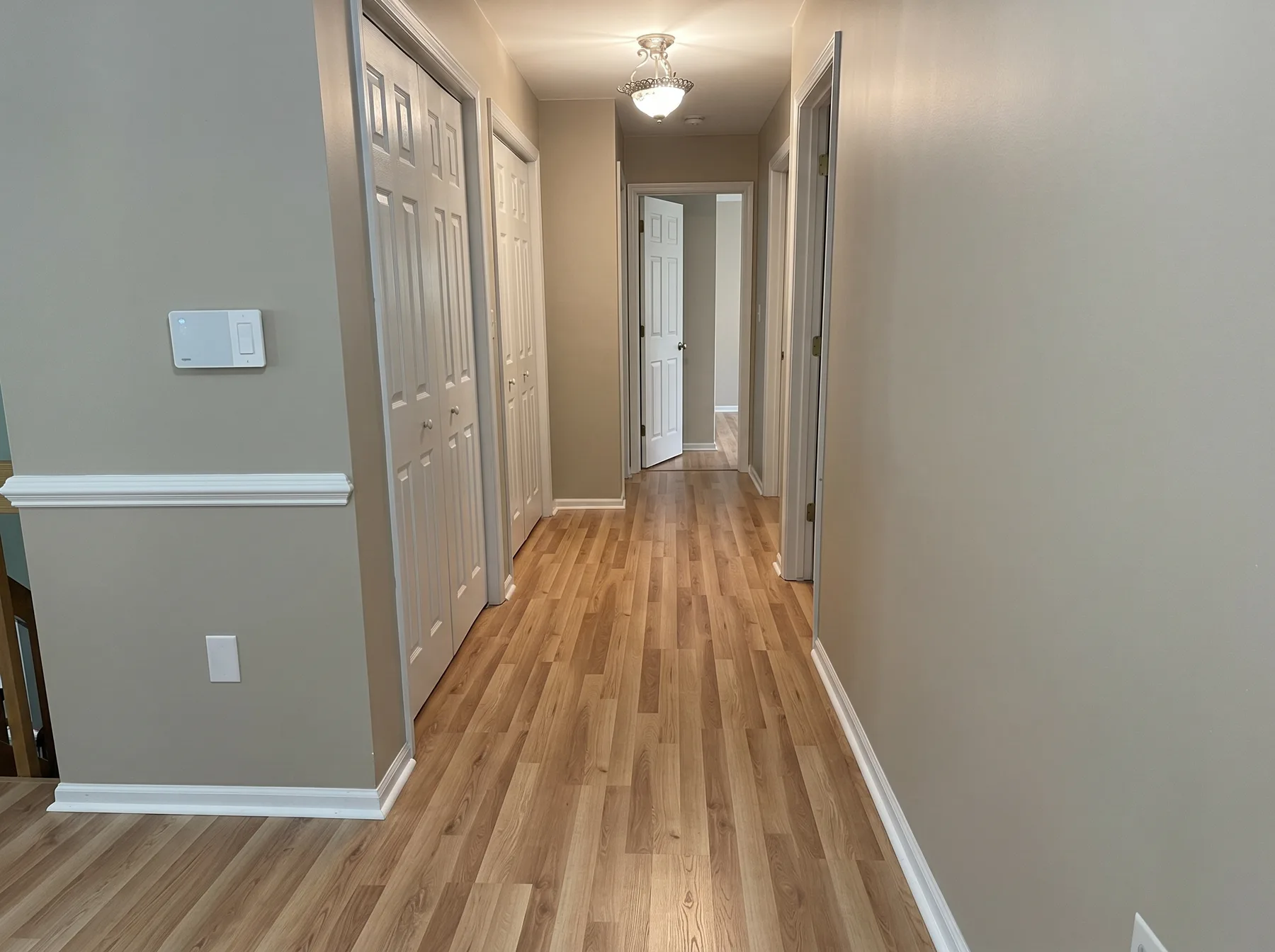 Finished hallway with natural wood-tone plank flooring in Catasauqua PA