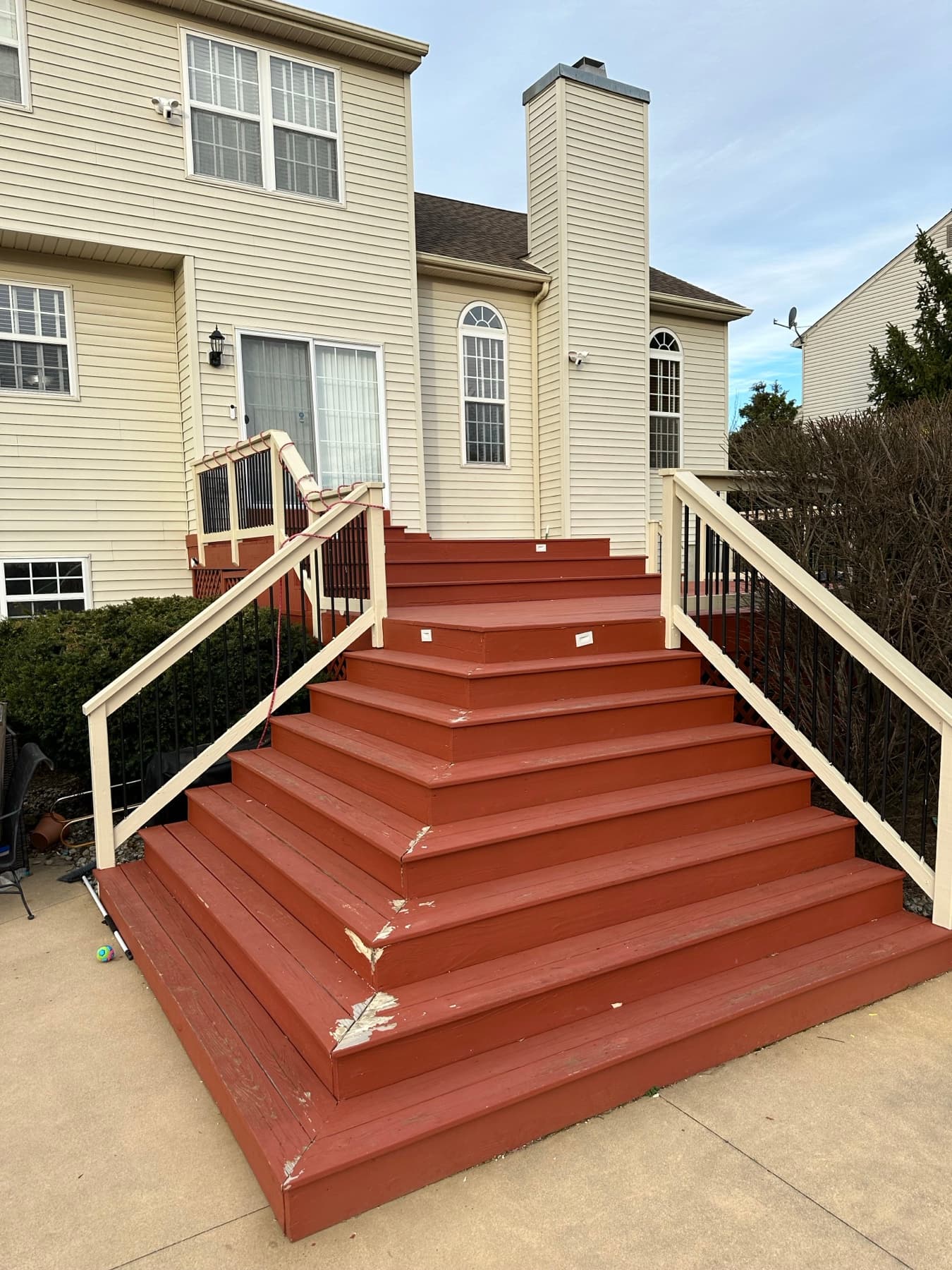Before photo of worn red deck stairs before a deck rebuild in Chestnut Hill Easton