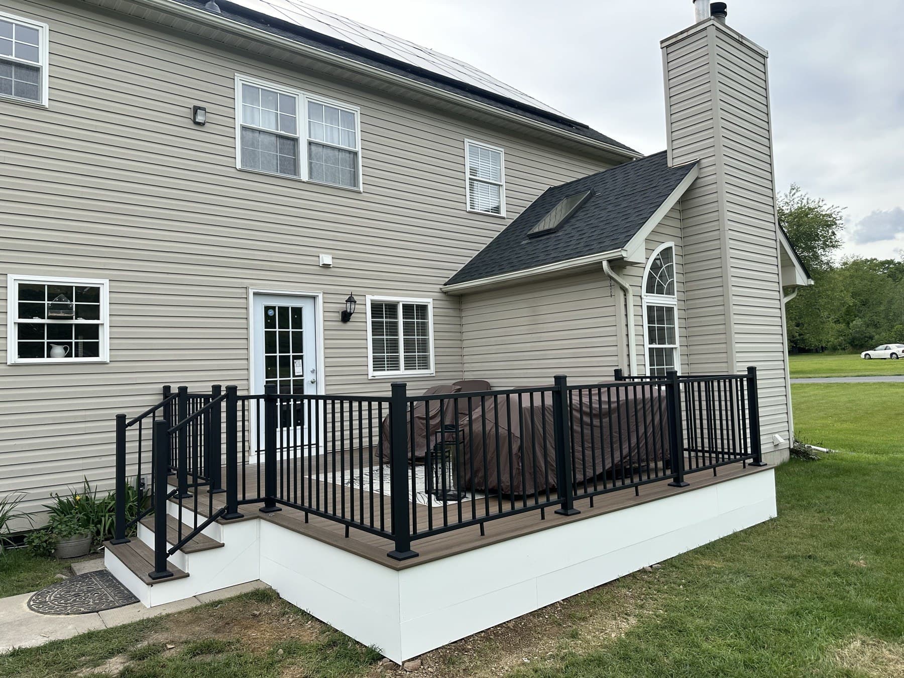 Finished backyard deck with black railing and white fascia in Emmaus PA