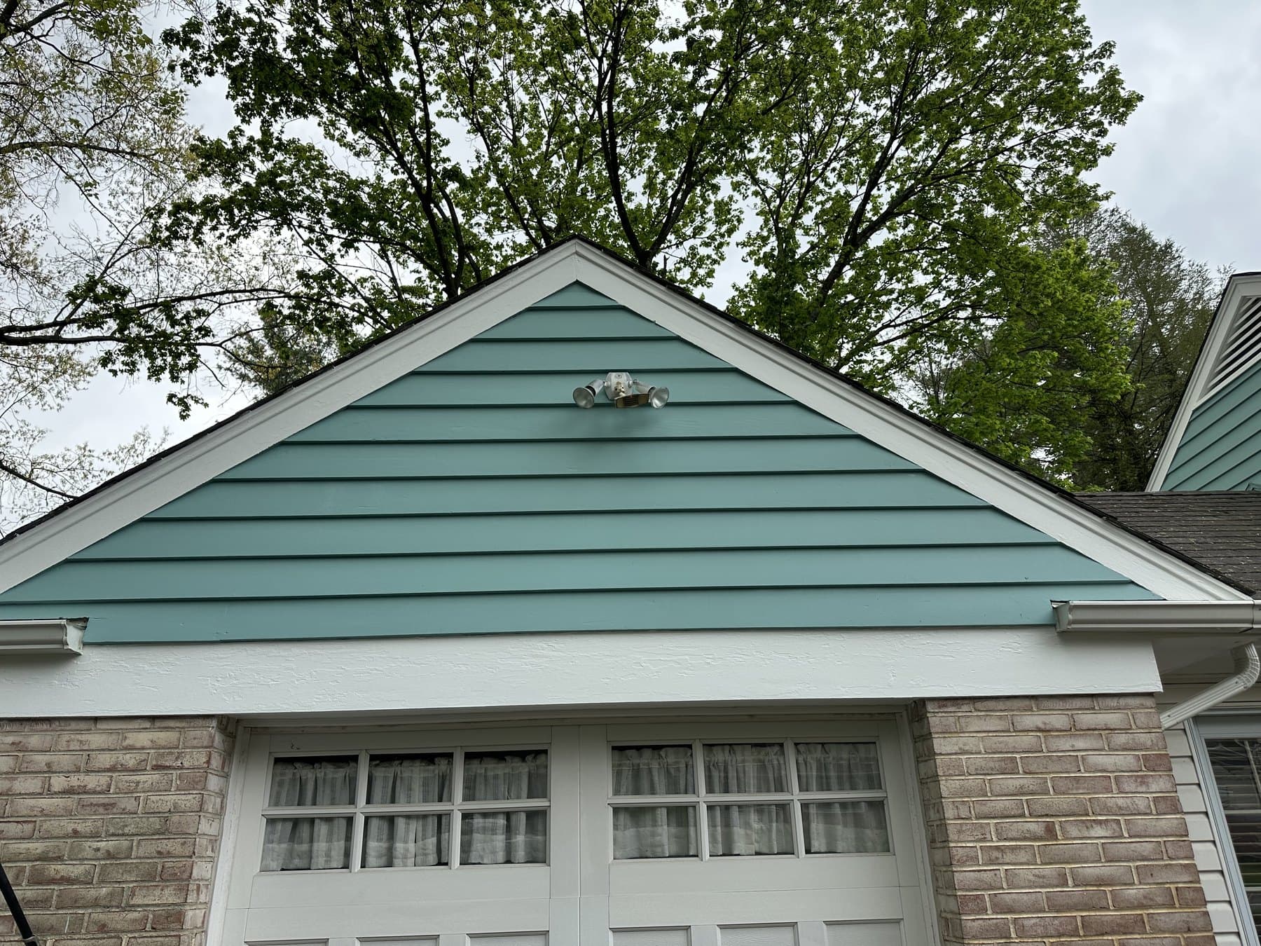 Finished garage gable with white trim and blue green siding in South Whitehall Township