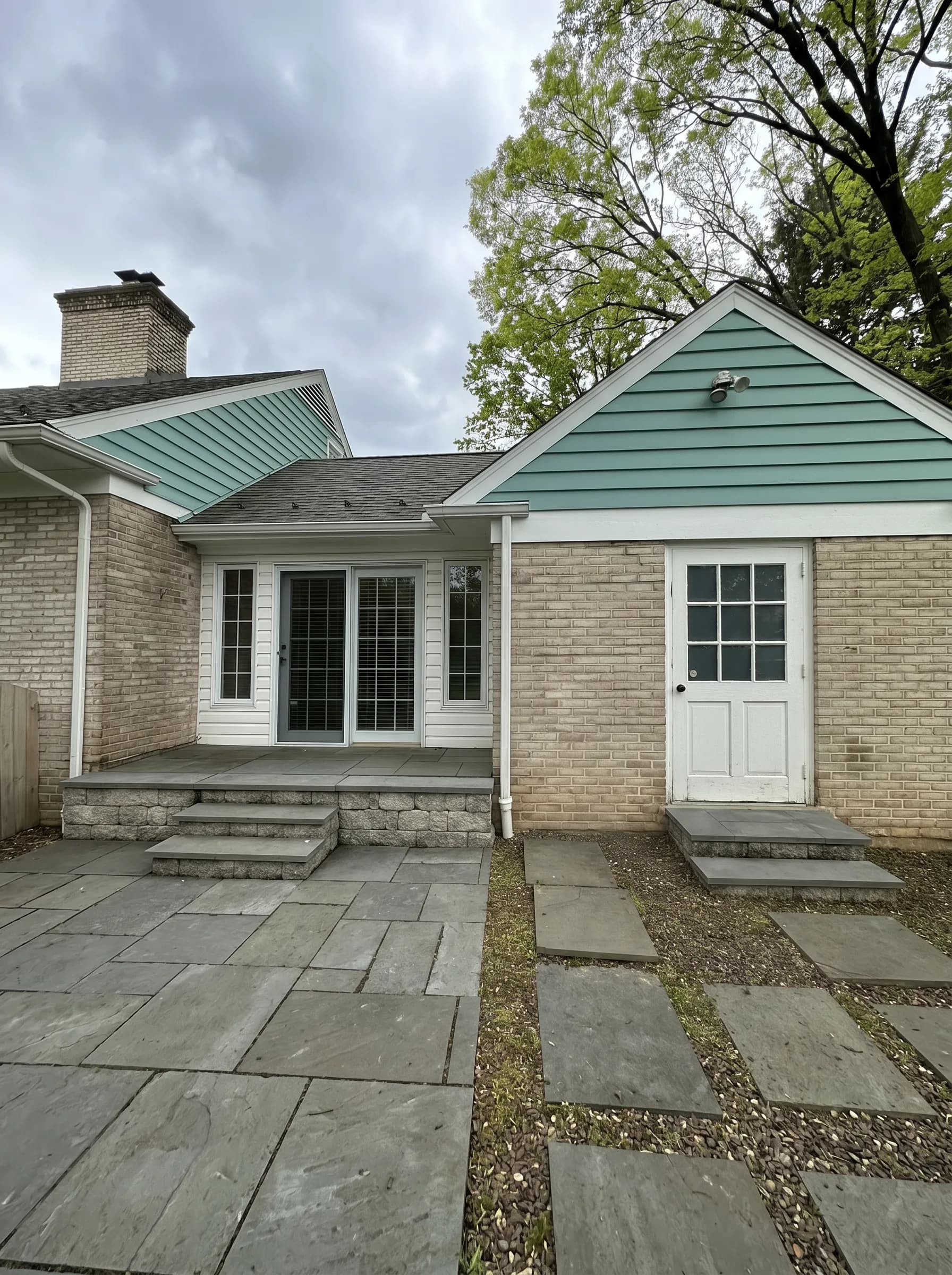 Finished rear exterior with blue green gables and white trim in South Whitehall Township
