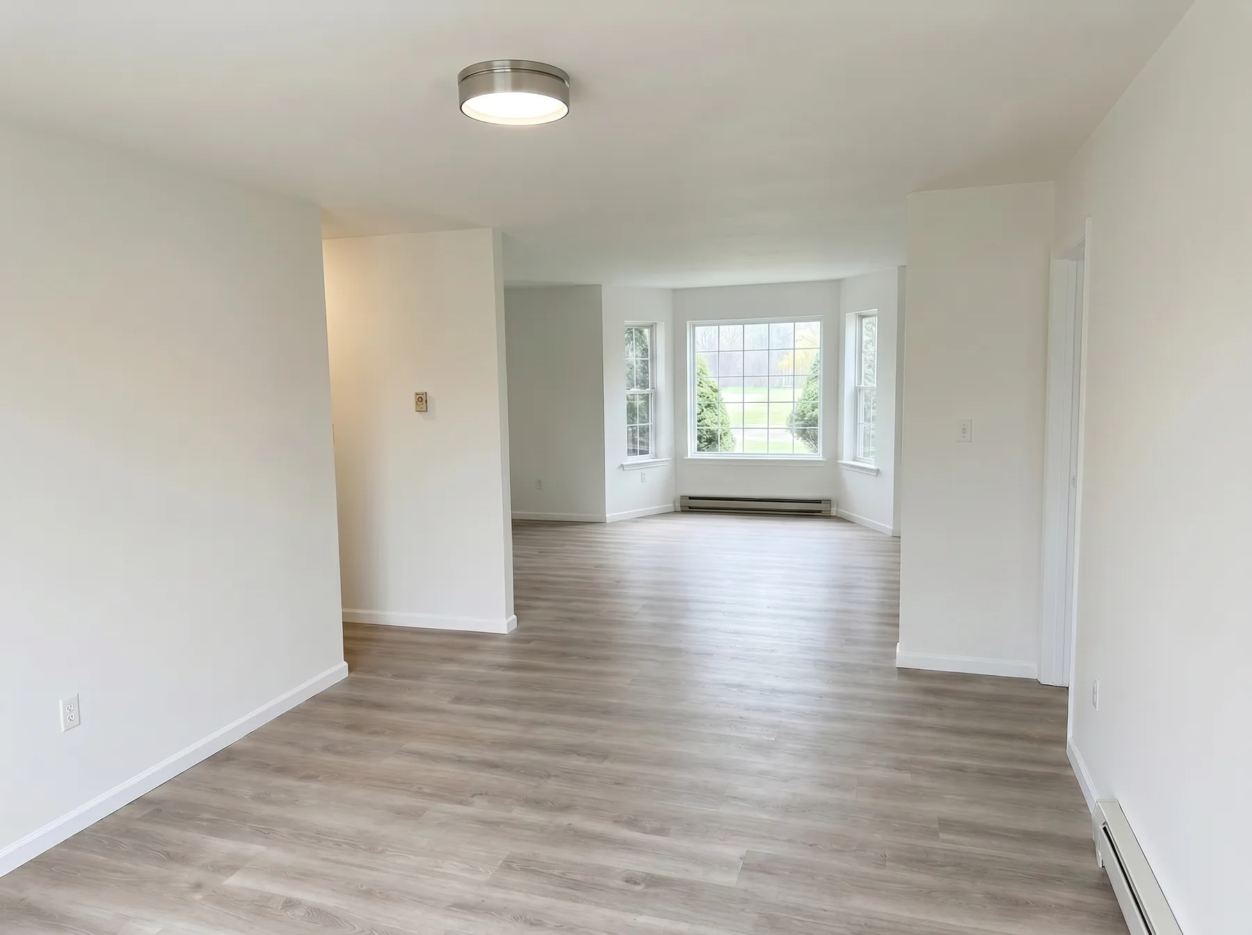 Finished living and dining area with bay window and wood-look flooring in Southside Allentown