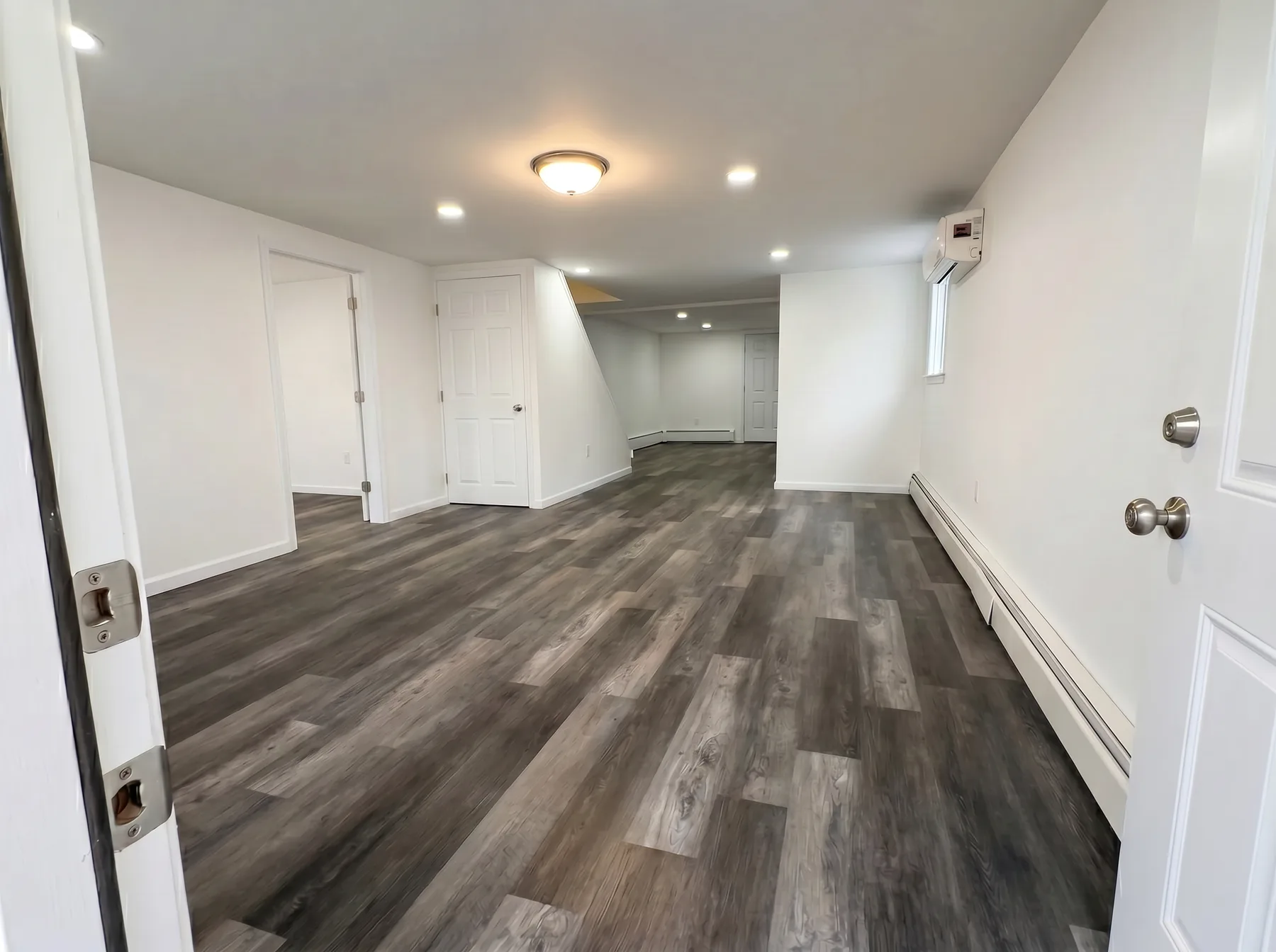 Finished open main room with LVP flooring and recessed lights in Bethlehem