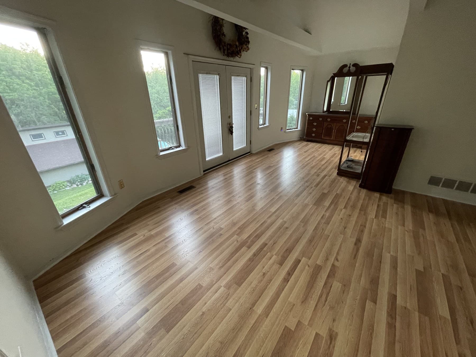 Finished bedroom with natural wood-tone plank flooring in Catasauqua PA