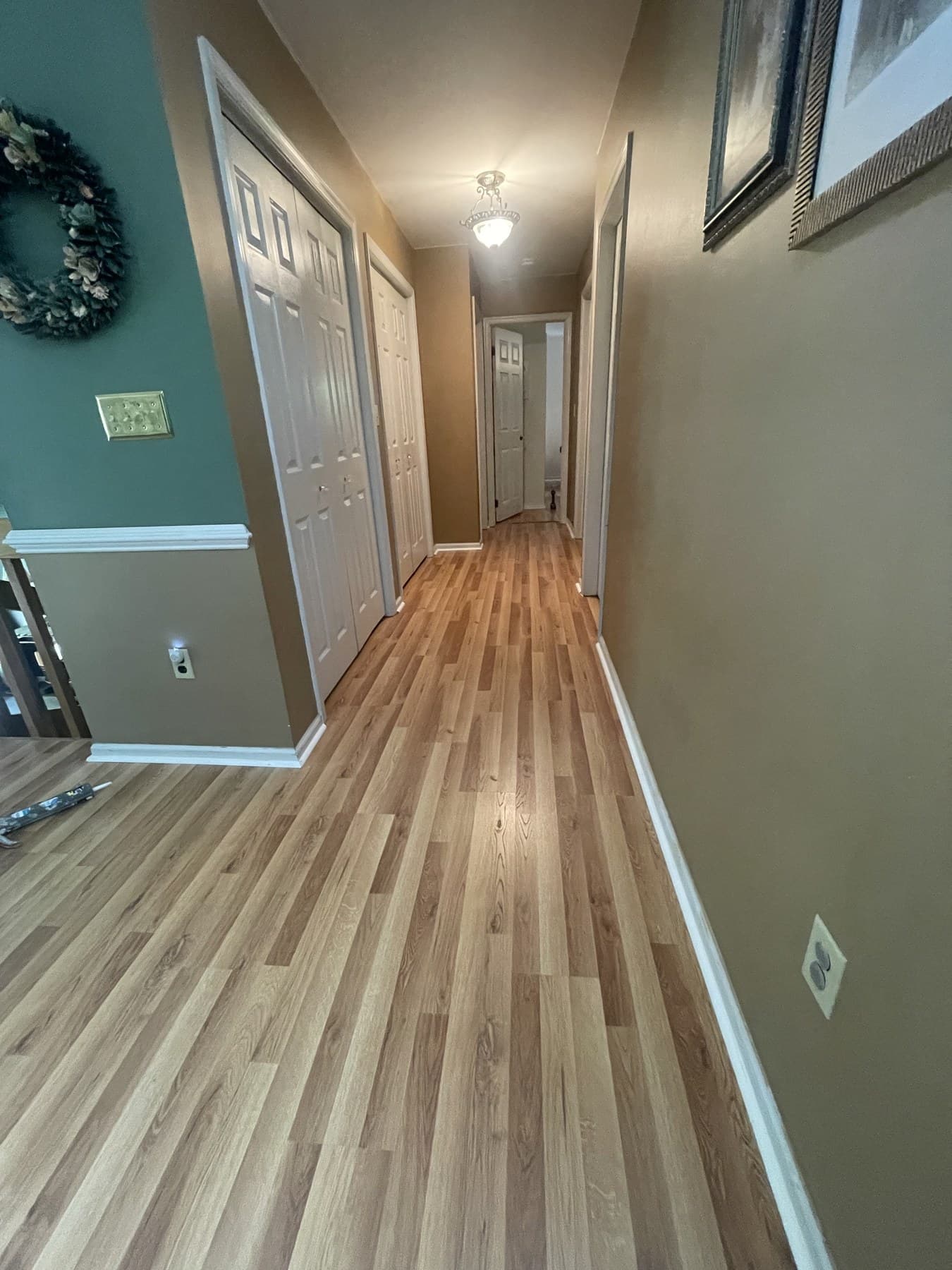 Finished hallway with natural wood-tone plank flooring in Catasauqua PA