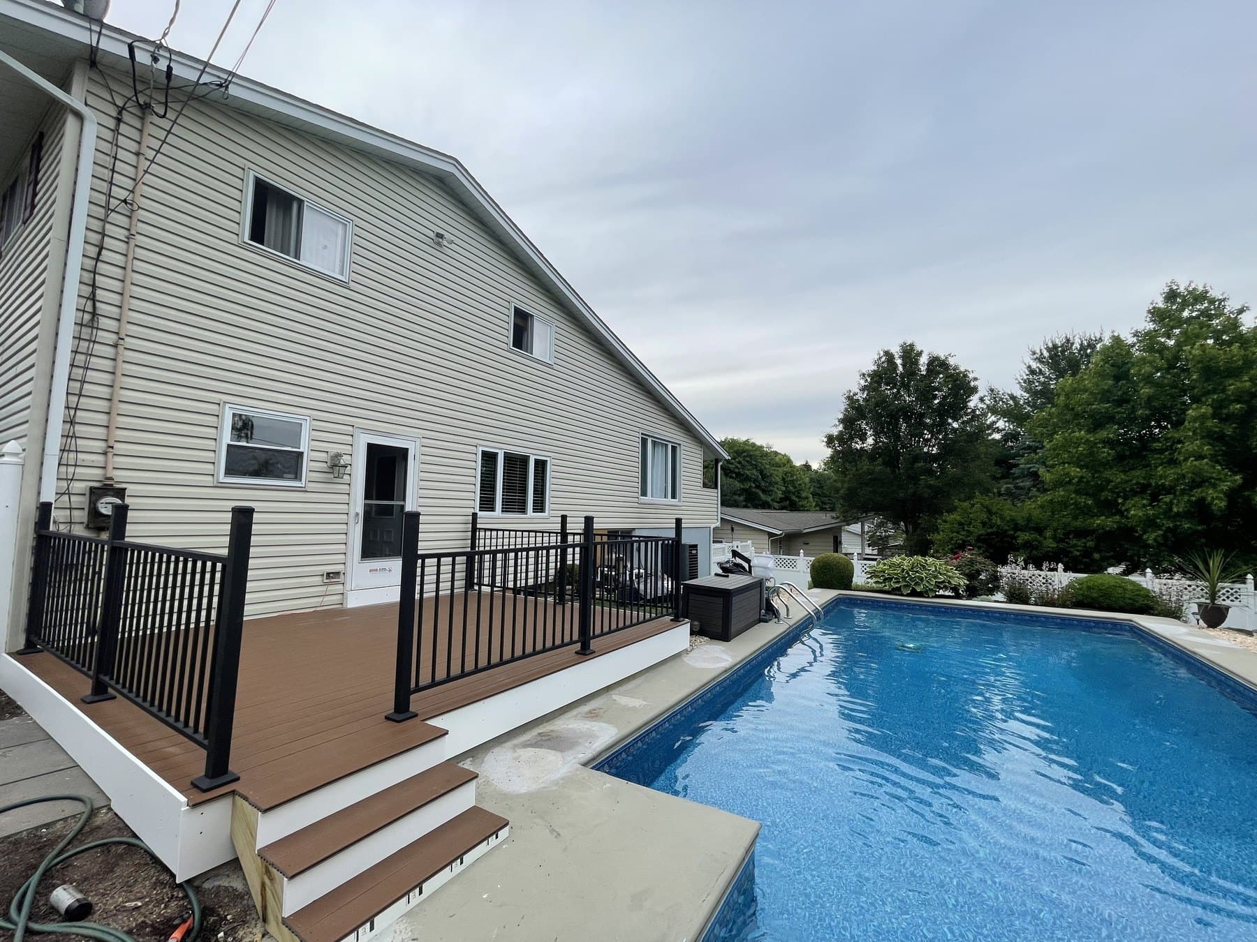 House side view of finished poolside deck stairs and railing in Hellertown
