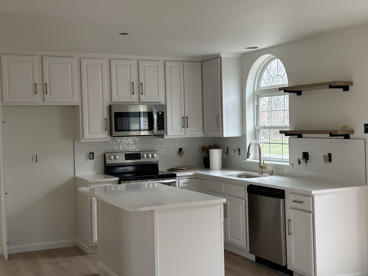 Finished white kitchen with cabinet wall and island
