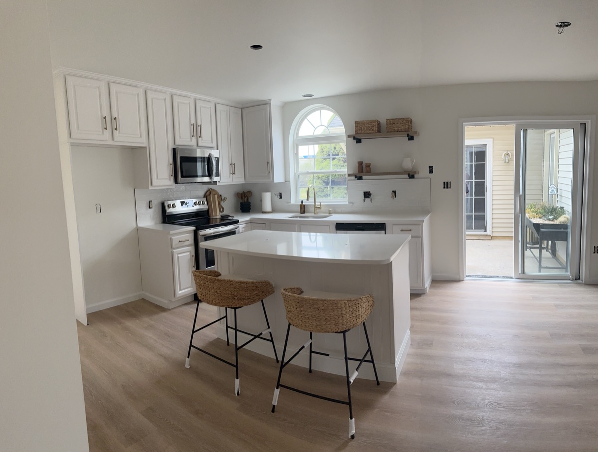 White kitchen remodel facing the island and patio door