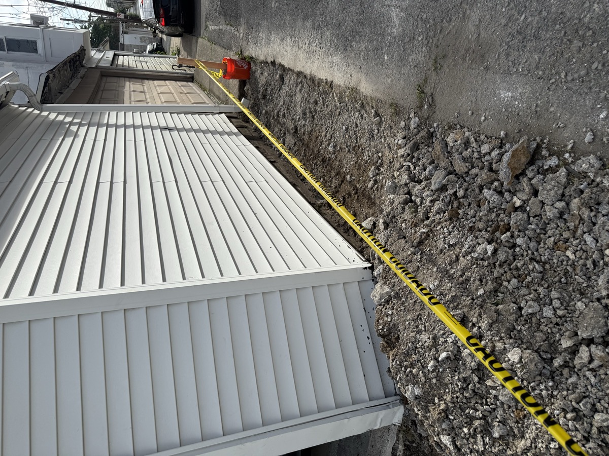 Fresh siding and grade work along the side of a house