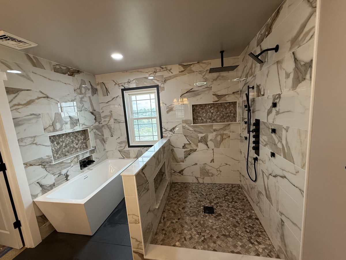Wide bathroom view with shower, tub, and vanity