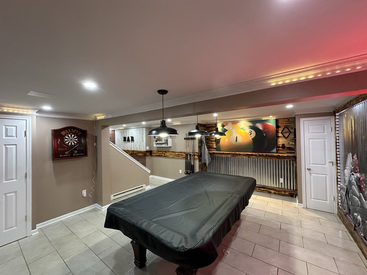 Finished basement entertainment space with bar and seating area