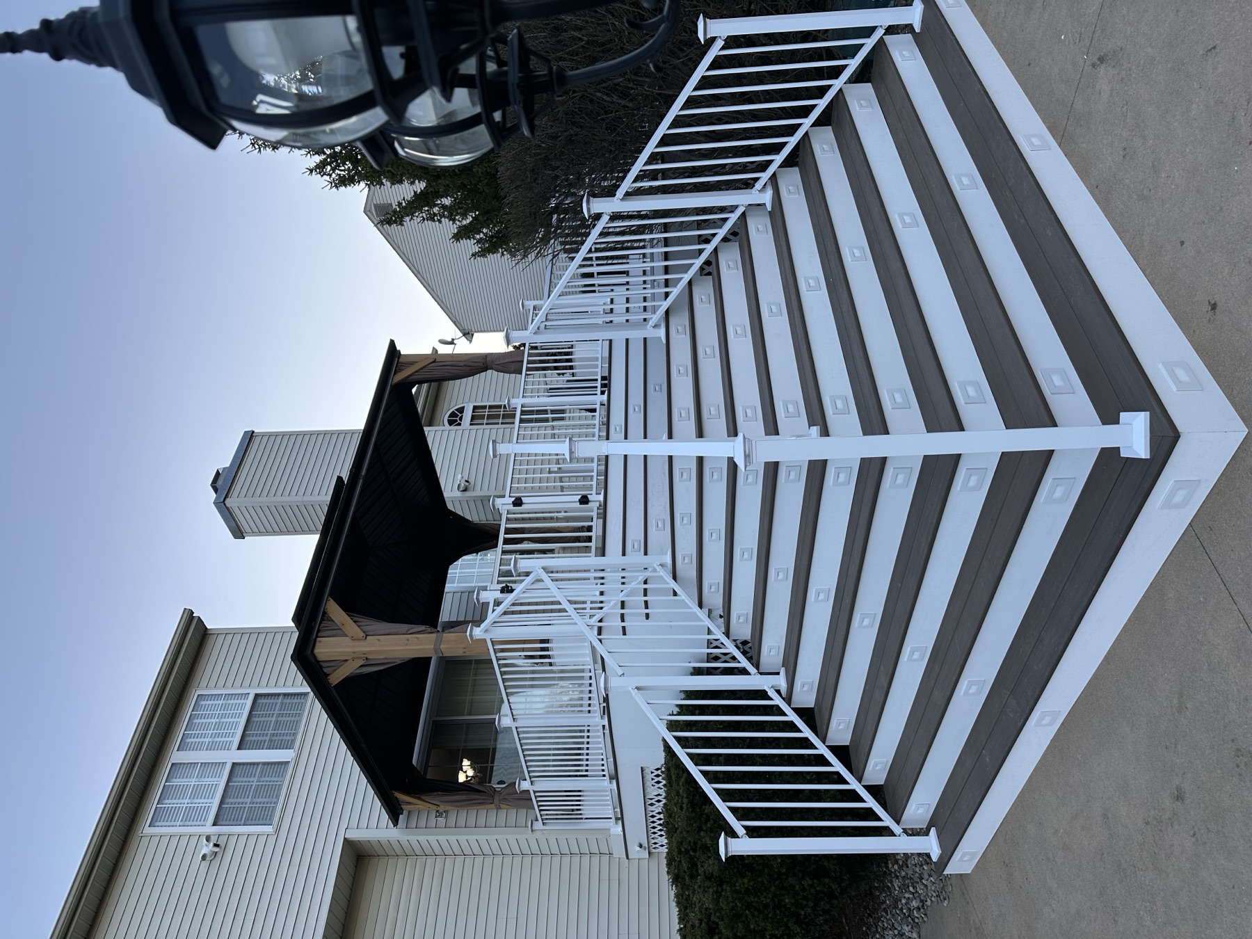 Finished deck stair rebuild with gray treads and white vinyl railings in Easton PA