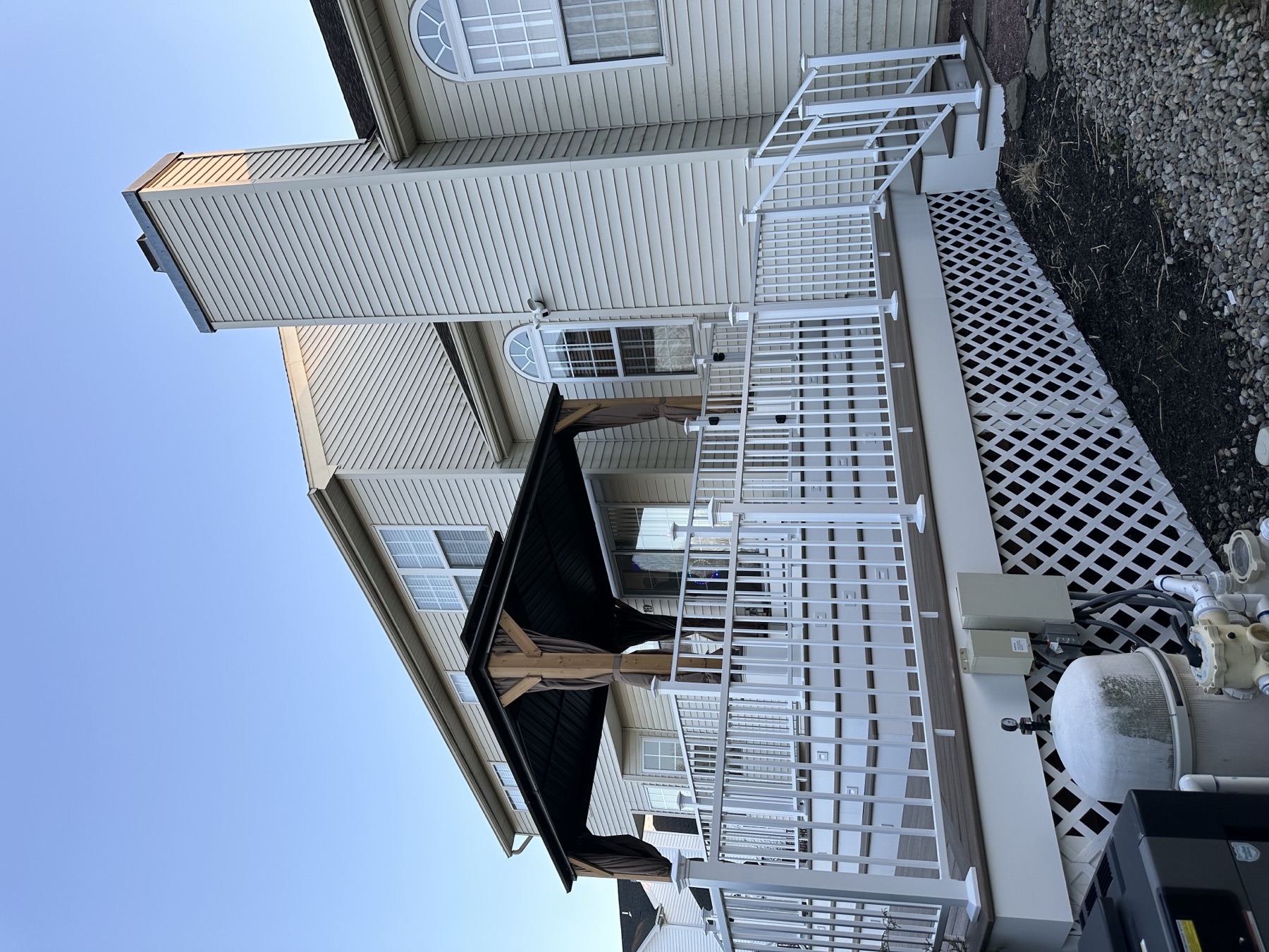 Side view of finished deck with vinyl railing lattice and gazebo in Chestnut Hill Easton