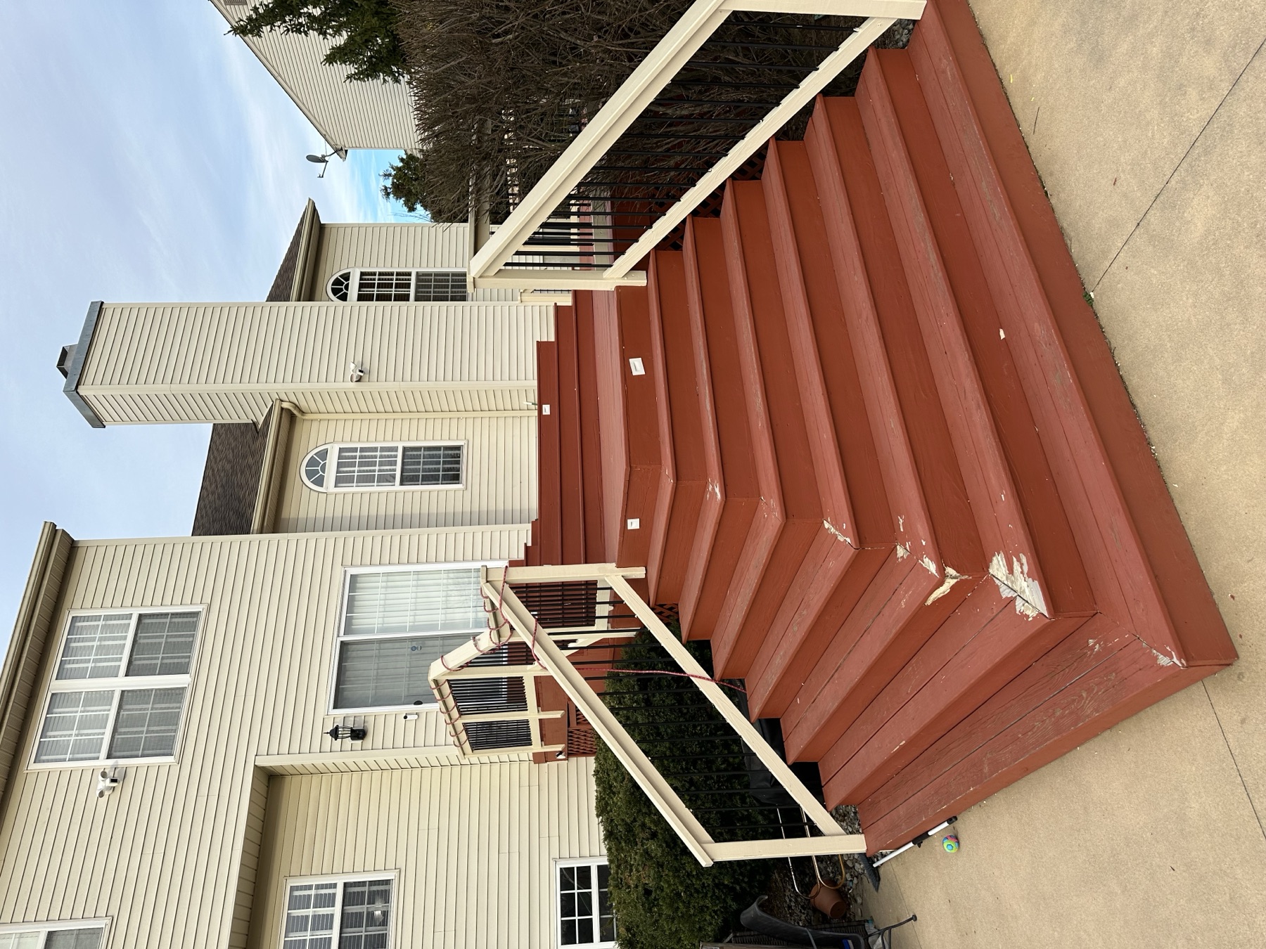 Before photo of worn red deck stairs before a deck rebuild in Chestnut Hill Easton