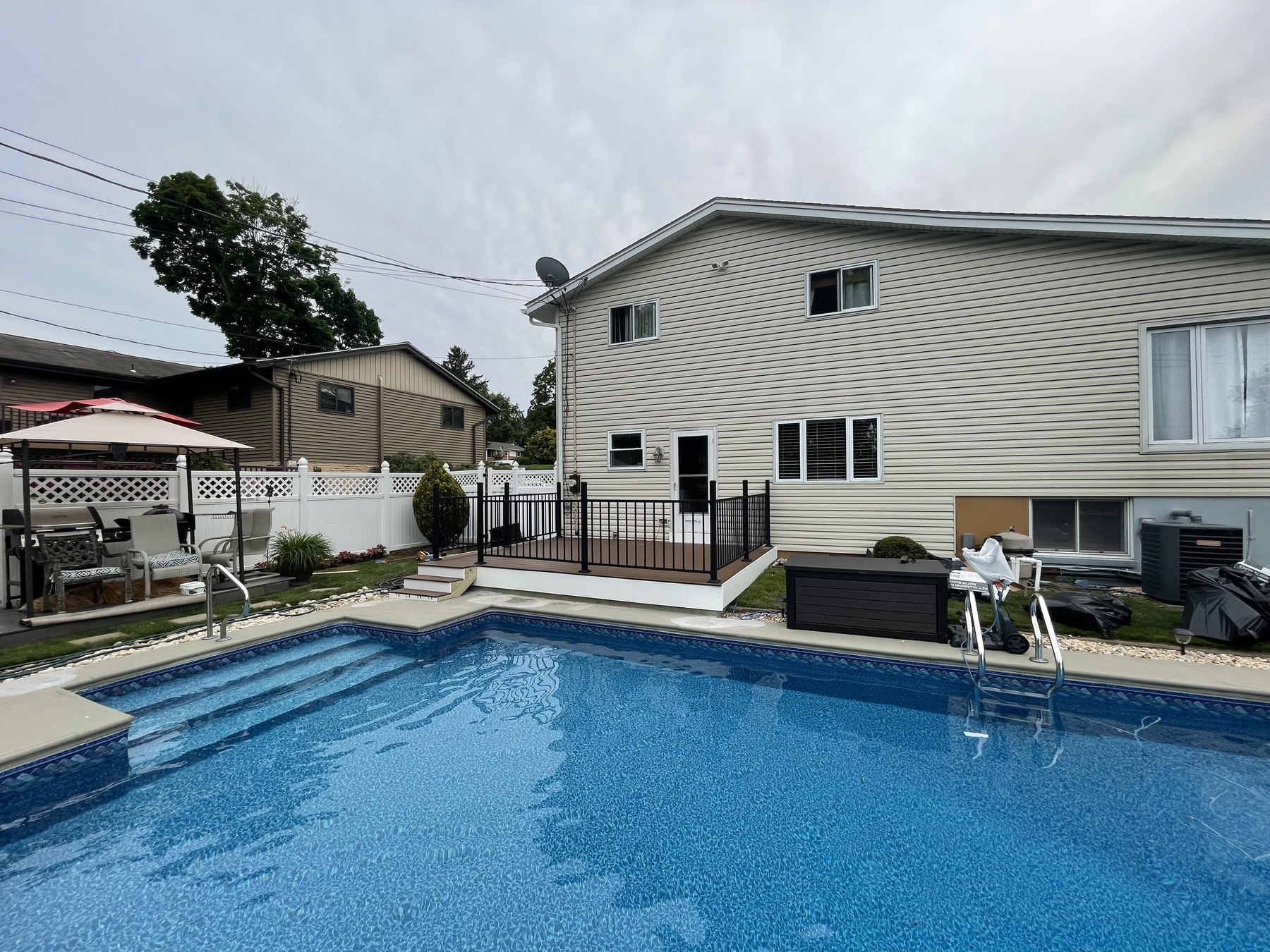 Wide view of finished poolside deck and black railing at a Hellertown house