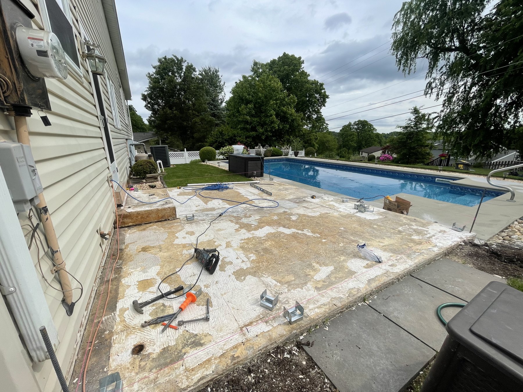 Before photo of patio and pool area before a poolside deck build in Hellertown