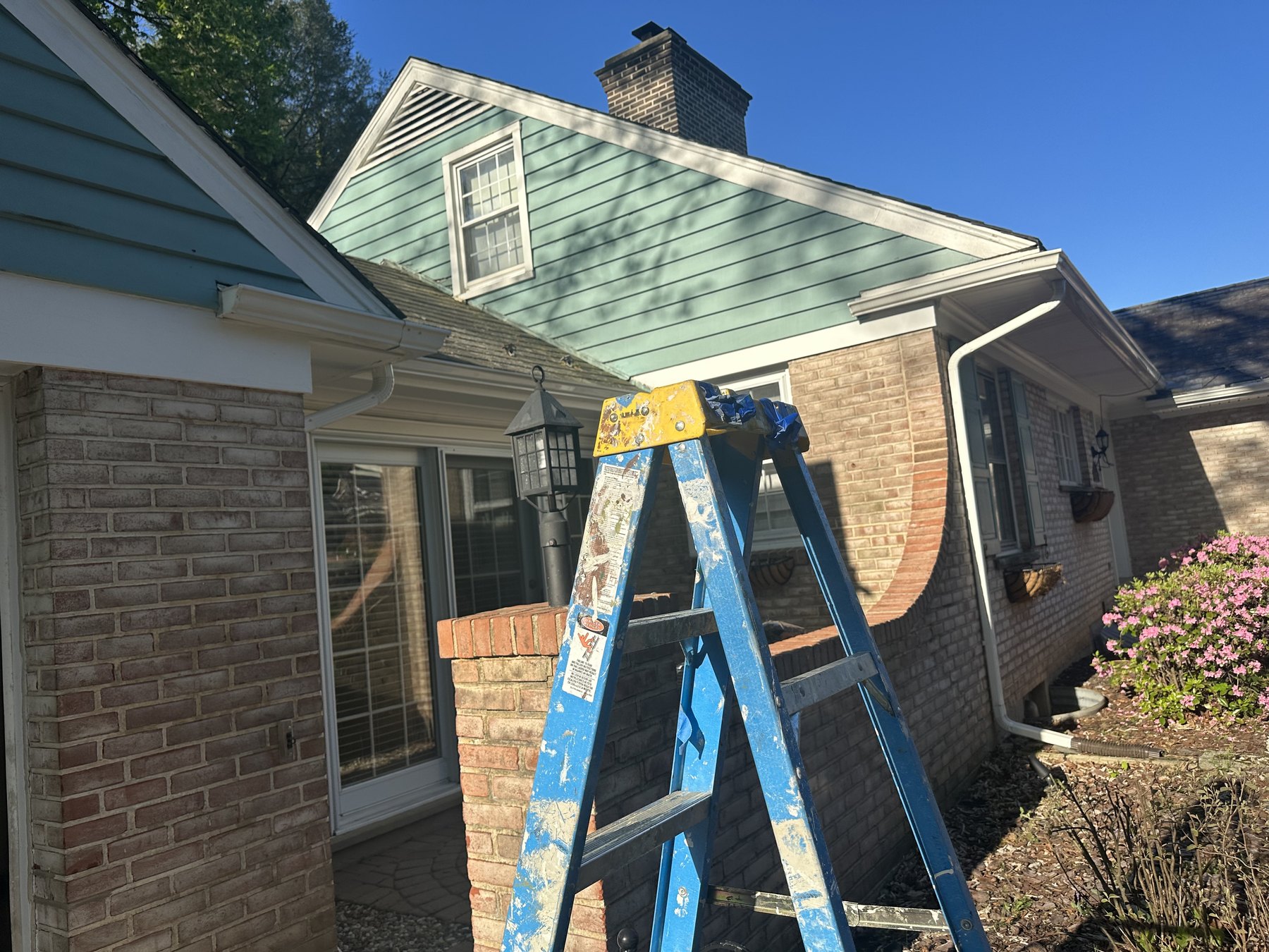 Exterior painter ladder at front gable during house painting in Allentown PA