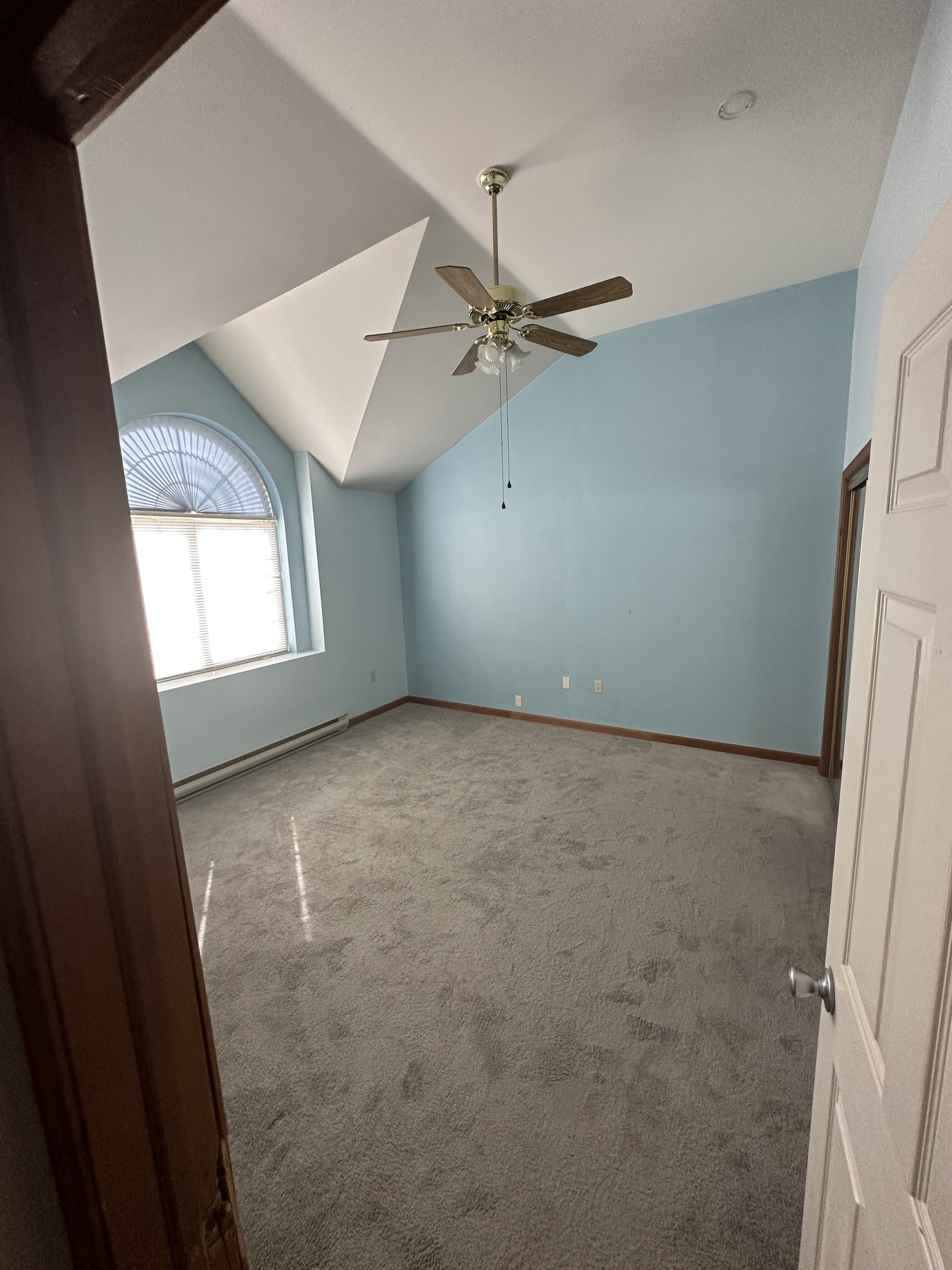 Before photo of bedroom with blue walls and carpet before renovation in Allentown