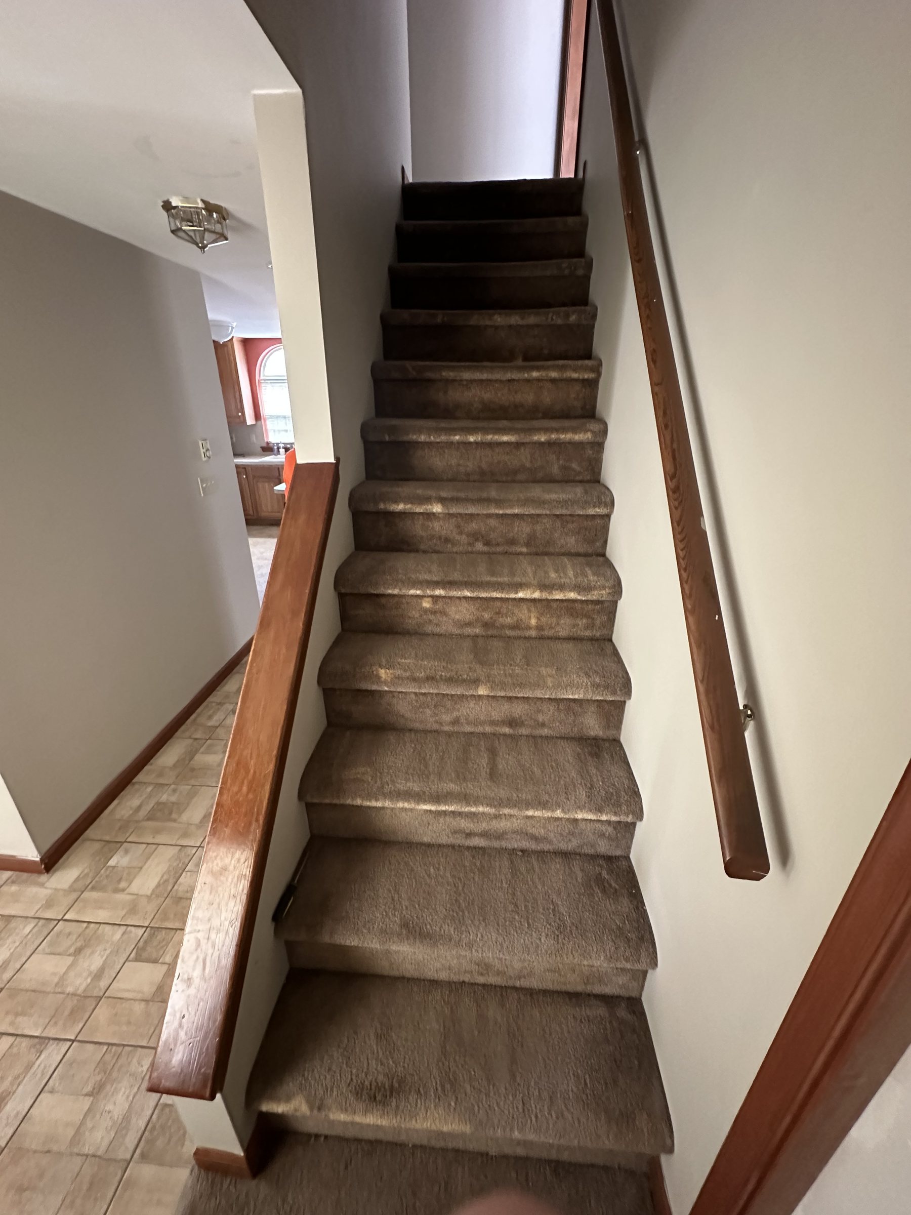 Before photo of carpeted stairs and wood trim before Southside Allentown renovation