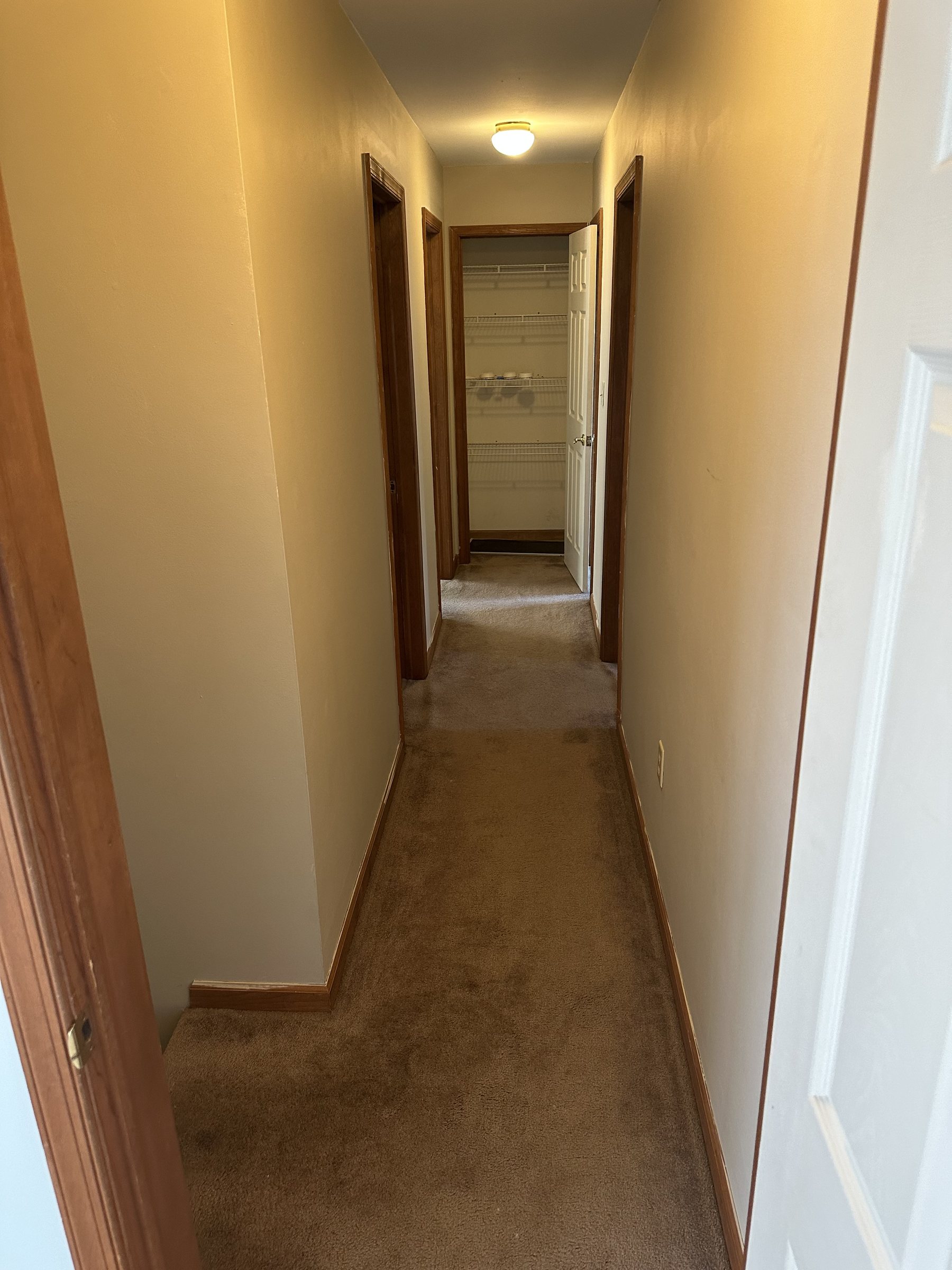Before photo of hallway with carpet and wood trim before renovation in Allentown PA