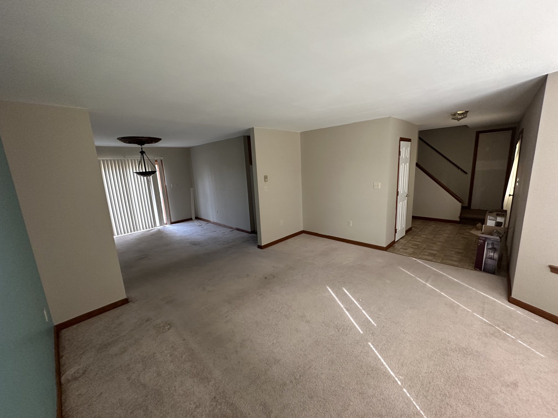 Before photo of open carpeted room with blue wall before Southside Allentown renovation