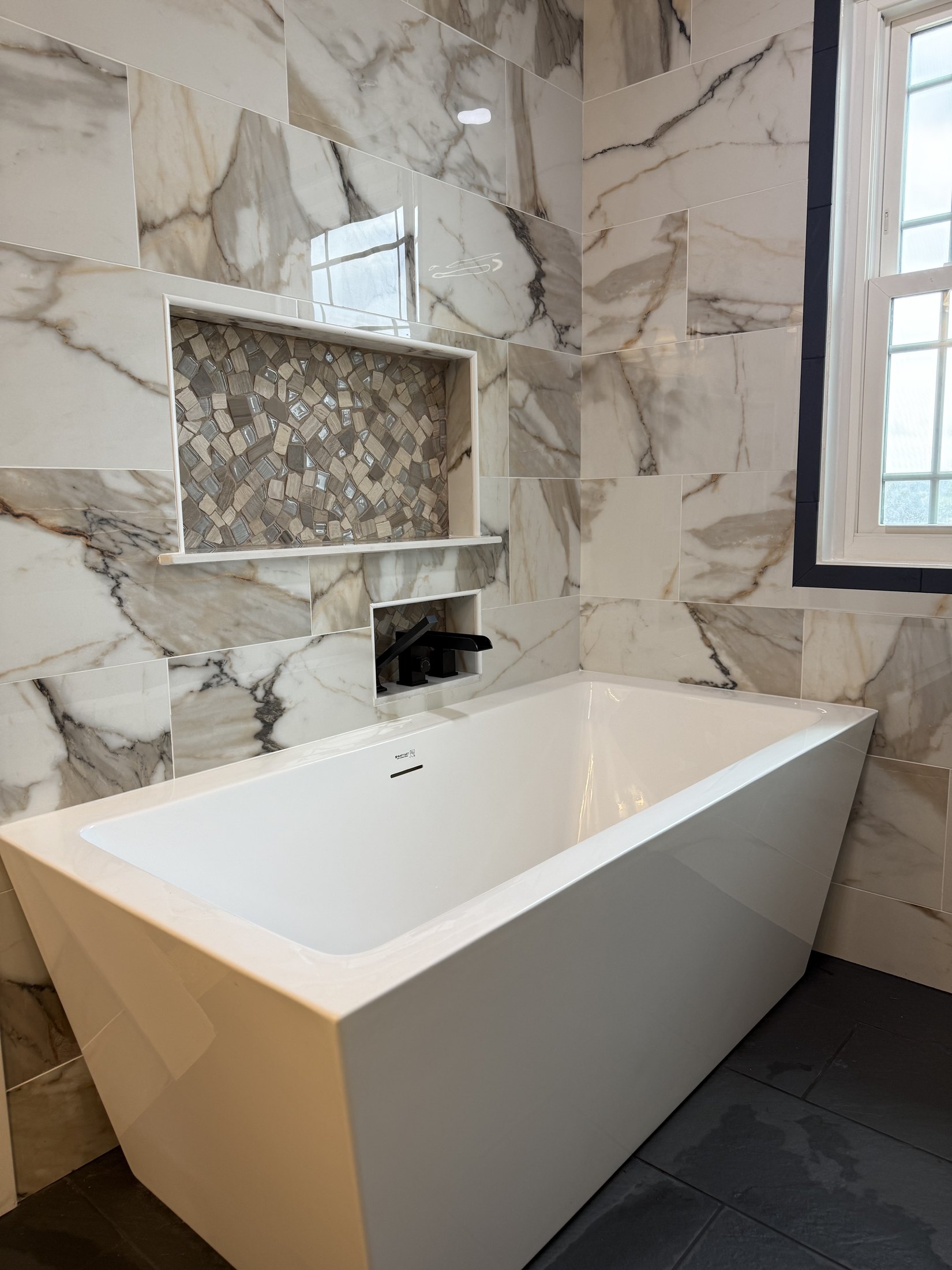 Finished freestanding tub with marble-look wall tile in West End Allentown bathroom