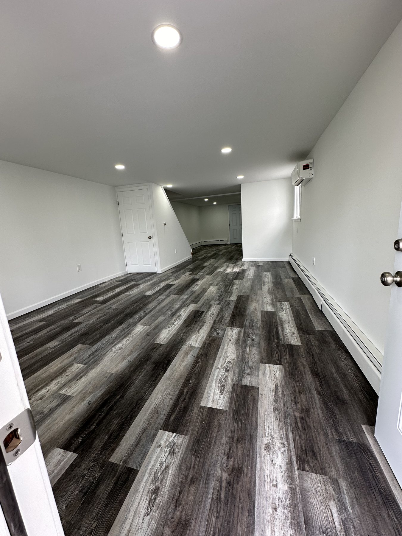 Finished long room with recessed lights and LVP flooring in Bethlehem